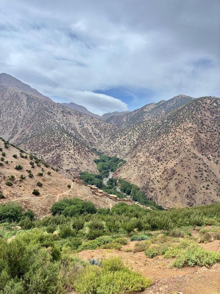 A small village beside a green river in a High Atlas valley